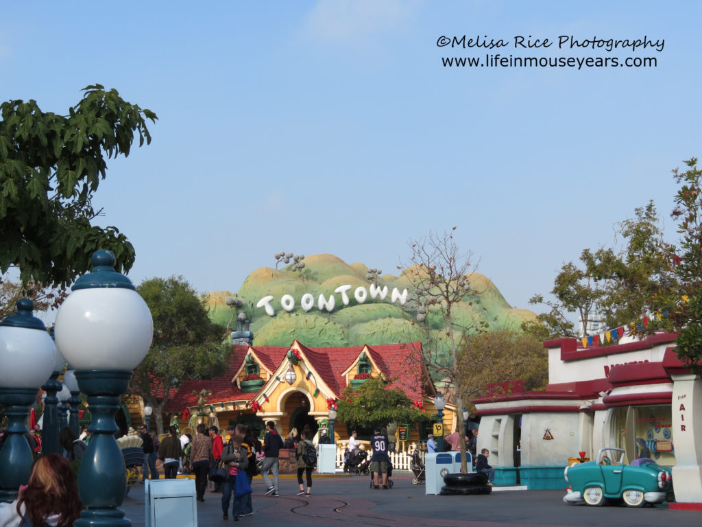 Some of the building's in Toontown. In the background is a green hillside with white letters spelling out Toontown.